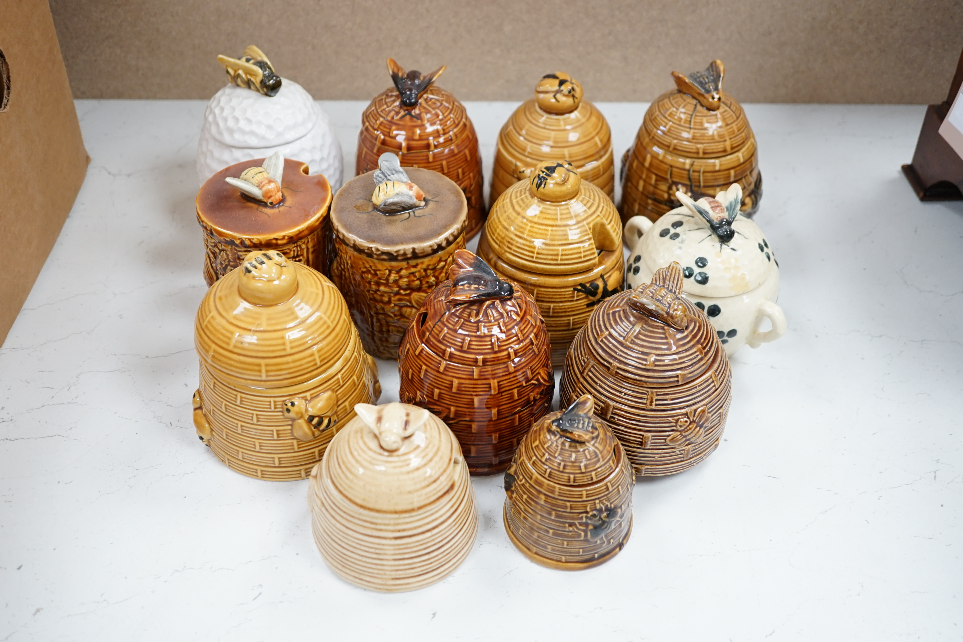 Thirteen various pottery honey jars and covers